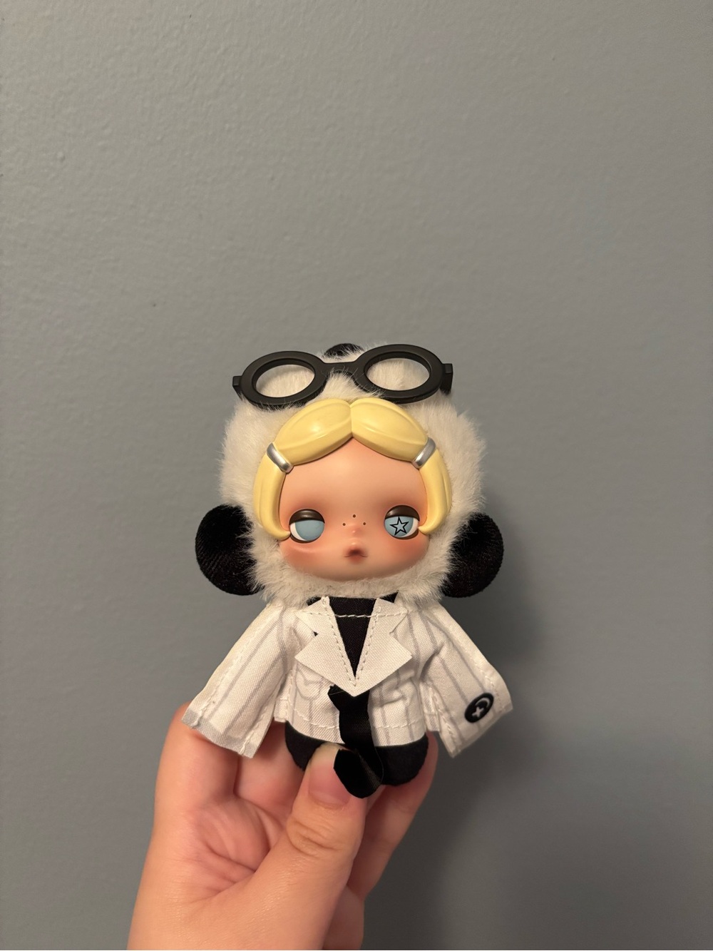 Plush character with white and black suit with black glasses